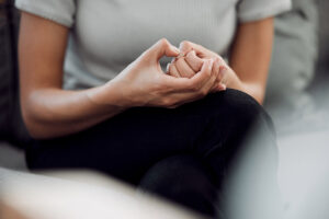 woman picking hands worriedly during a therapy session