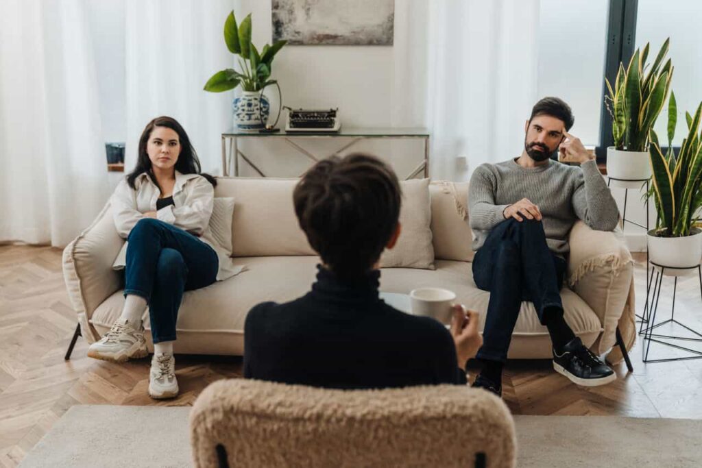 Unhappy married couple in quarrel sitting on opposite sides of couch during therapy session with family psychologist SSUCv3H4sIAAAAAAAACpyRTW6DMBCF95V6B+R1kADTALlK1MX4h2DFsSPbpKqi3L1jGyKvu2O+mXl+j3l+flQVYeAVJ6fqGSusldarDw6CsgZxc9i4k0ZIV5KHo8emBKDKSgoVrFOgS8gg8MXATSI0q9YRv1KT+ABh9dJHLxviEOQFNTJ8S2TD51xXeyM1cQNbhBwK5leW2I6y+L8288f3O/BFGv6bDBdBnNQScpBzHiXXnyDdrYwGq1C2SPWwHHQcoIXS3SmuzKVYs2FJR9jXuF1NcNHC2znR1t6B6fiLZ9SUO1/AexwXOy8e4nhyeyveMTakAJsqEXiJWLaUdj3taTvQdhy7caTbQL7eolAn2dmFsOZXJcroKjogYmgm1s19PbB+rvt2+qqhnWTdDXxsxpkNR9rjj3/9AQAA//8DAM/cDvCmAgAA